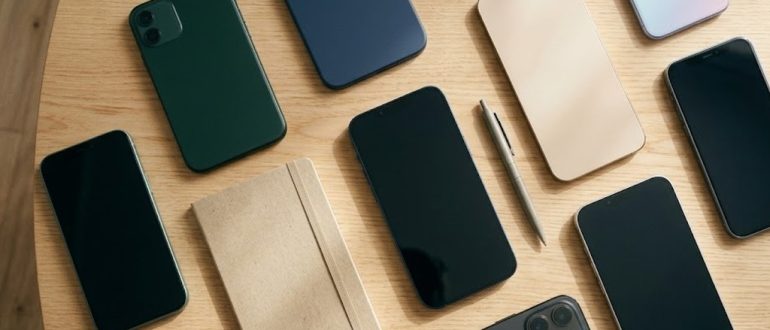 Несколько современных смартфонов разных цветов на светлом столе